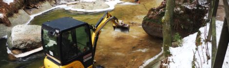 Minibagger graben im Flußbett