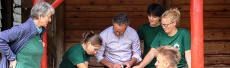 Bildunterschrift: Foto: A. Schöntag Der Filialdirektor der Commerzbank Pirna und Dresden-Leuben, Stefan Luhn (M.) legt letzte Hand an bei dem Umbauprojekt Schafstall zu Erlebnisstation der Commerzbankpraktikanten Clara, Emma, Magda und Hannes. Mit Hilfe eines Models bringt er Tierspuren ein, um künftig Kinder und Jugendliche für Natur- und Umweltthemen zu begeistern. Umweltbildungsleiterin Margitta Jendrzejewski (l.) ist dankbar für die langjährige Unterstützung der Commerzbank und die immer wieder neuen Impulse der jungen Umweltexperten.