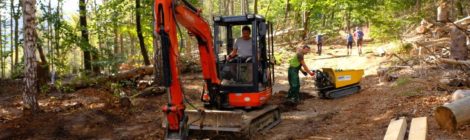Mit Bagger und kleiner Raupe wird ein Wanderweg repariert.