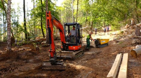Mit Bagger und kleiner Raupe wird ein Wanderweg repariert.