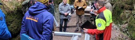 Foto: Hp. Mayr Bei der gestrigen öffentlichen Bauberatung stellte Uwe Borrmeister (3. v. r.) Leiter der Nationalpark- und Forstverwaltung Sächsische Schweiz vom Sachsenforst die Baumaßnahmen an den Steiganlagen in den Schwedenlöchern den berührten Bürgermeistern und der Presse vor. Bauingenieur Martin Aulitzky (r.) von der Nationalpark- und Forstverwaltung erläuterte die nächsten Schritte des Baus mit dem neuen von Hand heran transportierten Stahlträgern. Harry Dintner (Mitte links) aus Lohmen, hat 1967 am Bau der bisherigen Stufenanlagen mitgewirkt und interessierte sich sehr für die Rekonstruktion der Stiegen.