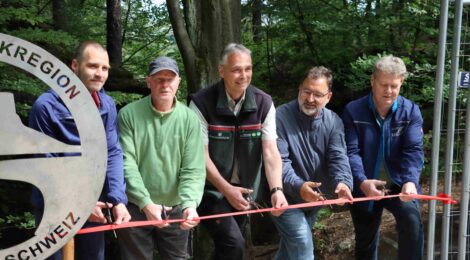 Bildunterschrift: Foto: J. Weber Der verantwortliche Planer Lucas Schmitt, Ralf Kaiser, der die meisten schwere Tragearbeiten geleistet hat, Uwe Borrmeister, Leiter der Nationalpark- und Forstverwaltung Sächsische Schweiz, Roman Rolof, Bürgermeister von Kurort Rathen, Torsten Grämer von Metallbau Lottes (v. l.) durchschneiden gemeinsam das Band zur Wiedereröffnung des Wanderwegs durch die Schwedenlöcher in der Nähe der Bastei im Nationalpark Sächsische Schweiz. Insgesamt in drei Bauabschnitten wurden die komplizierten Sanierungsarbeiten an Stiegen und Stegen im engen und steilen  Felsental durchgeführt.